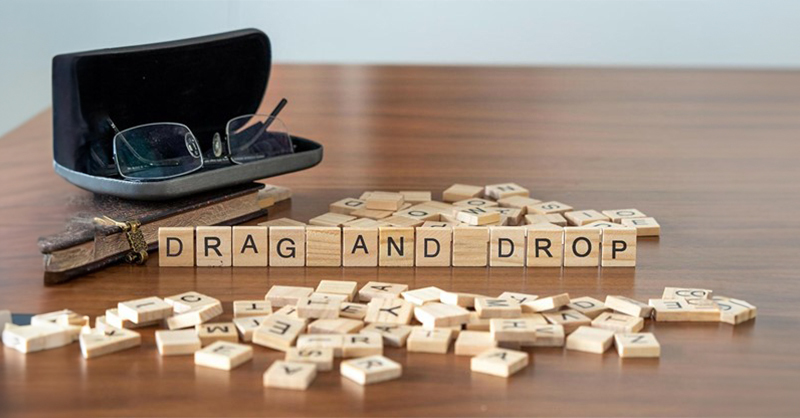 A power glass & dominoes on a table that reads "drag & drop"