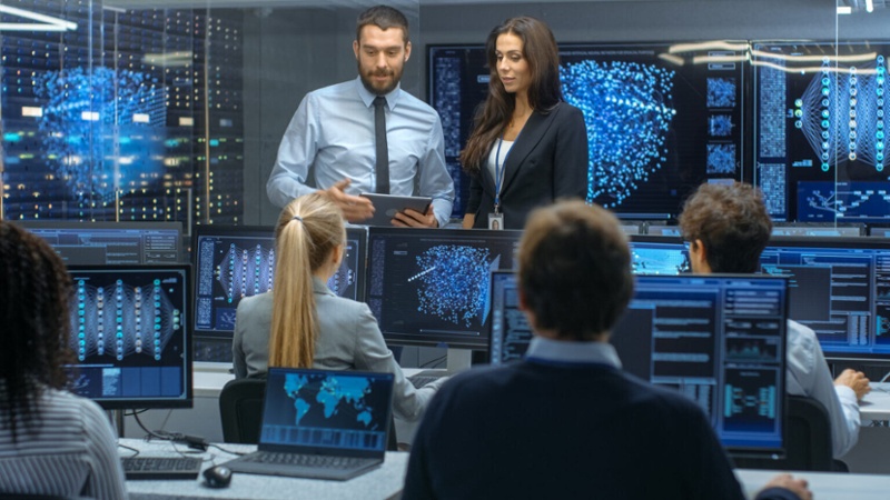 A group of individuals focused on their computers in a workspace.