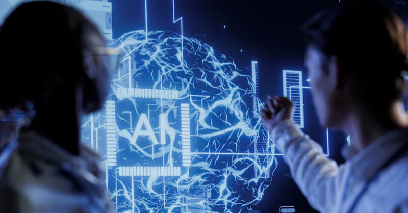 Two people examining a AI screen featuring a brain image, in connection with the theme